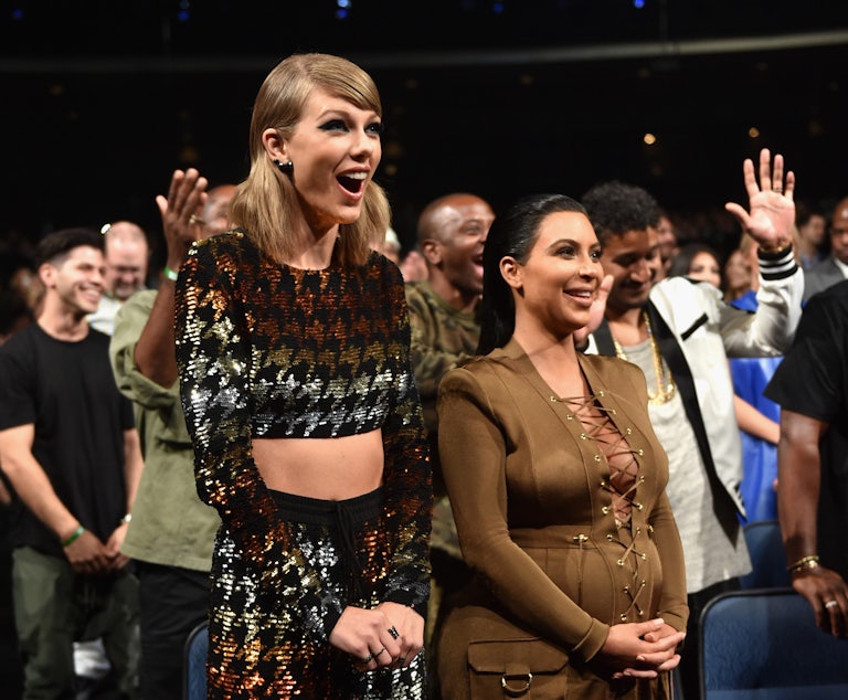 Taylor Swift and Kim Kardashian smile and stand next to each other