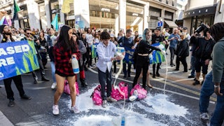 Demonstrators pour milk onto the street.