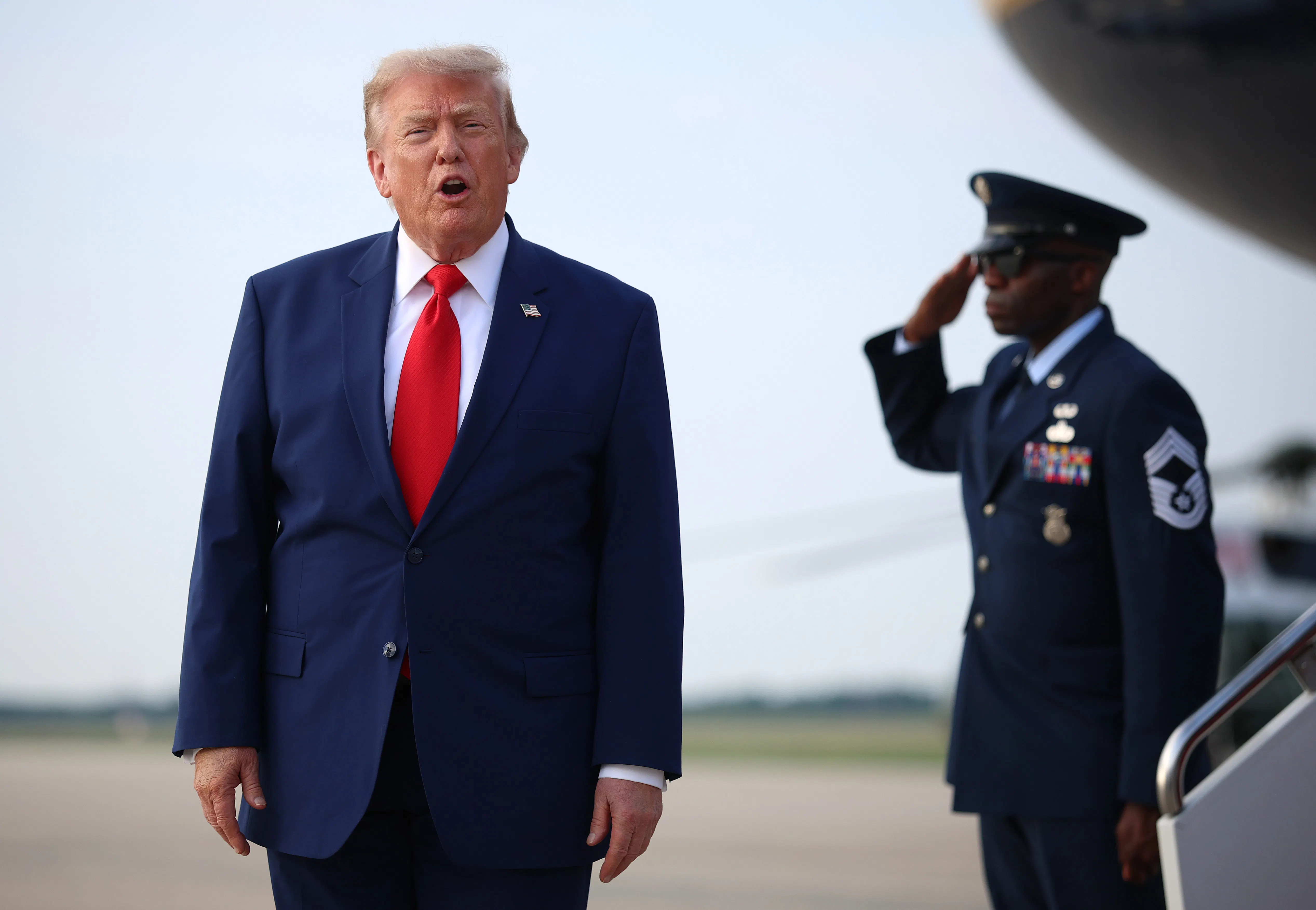 Donald Trump shouts at reporters after disembarking from Air Force One.