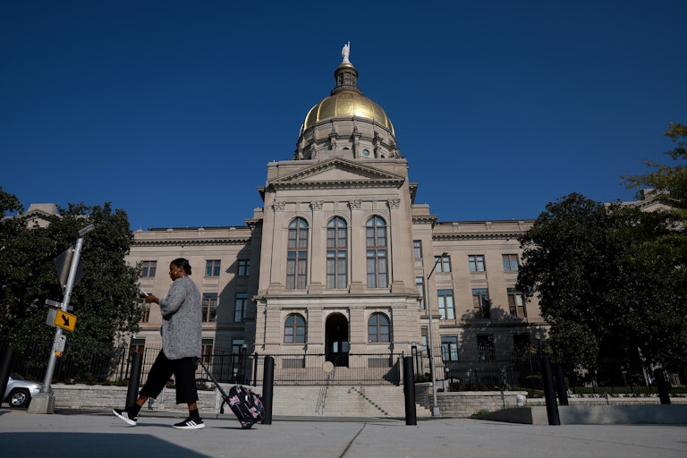 A woman walks in front of the Georgia state Capitol building