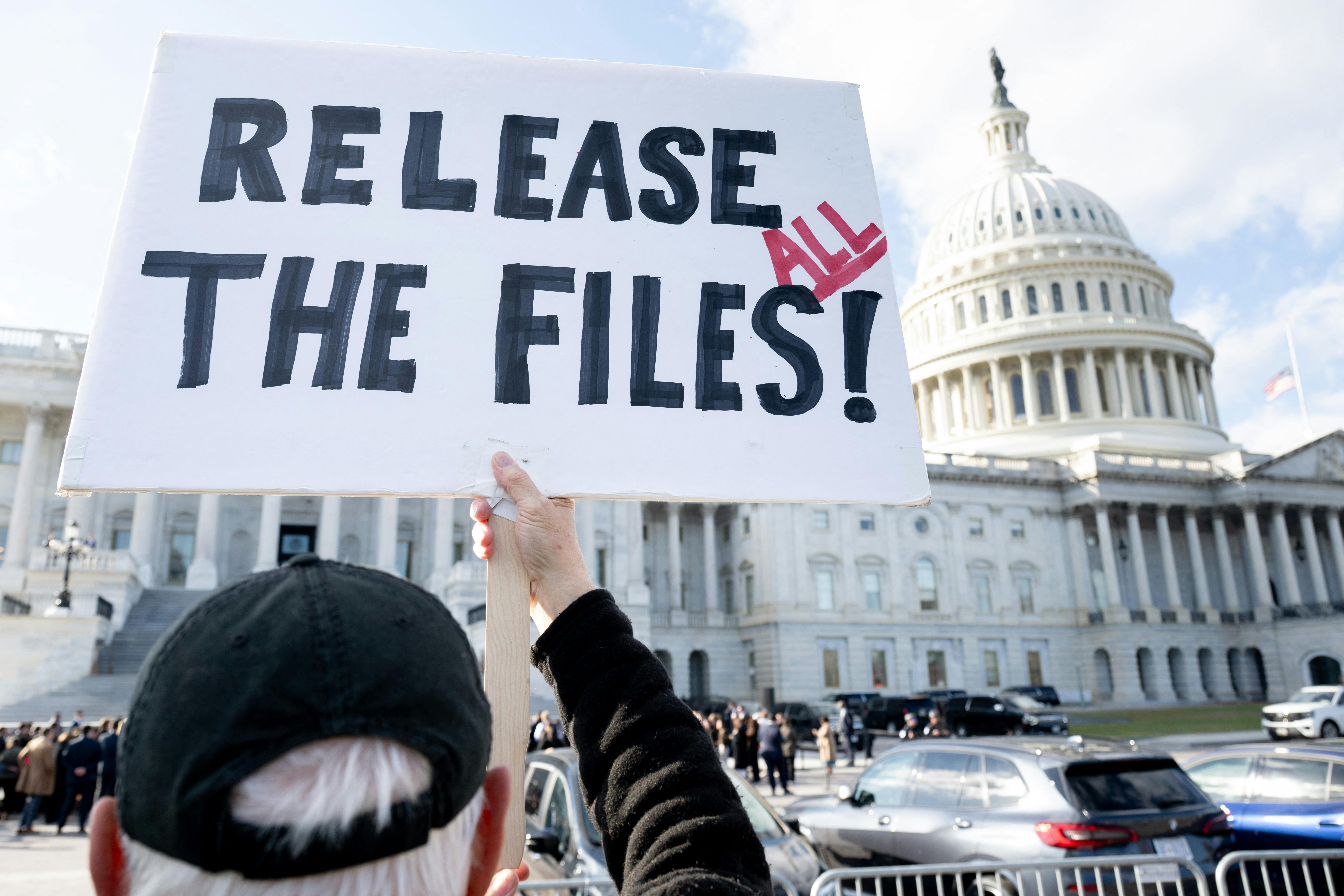 A person holds up a sign that says, “Release all the files!” outside the Capitol