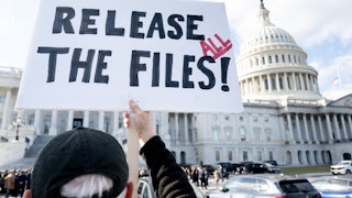 A person holds up a sign that says, “Release all the files!” outside the Capitol
