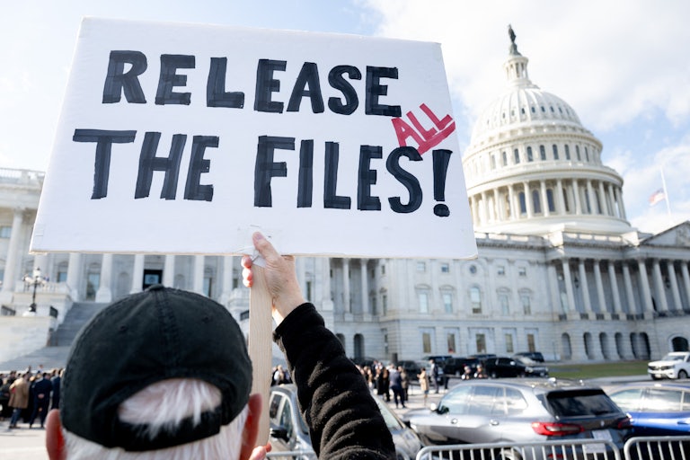A person holds up a sign that says, “Release all the files!” outside the Capitol