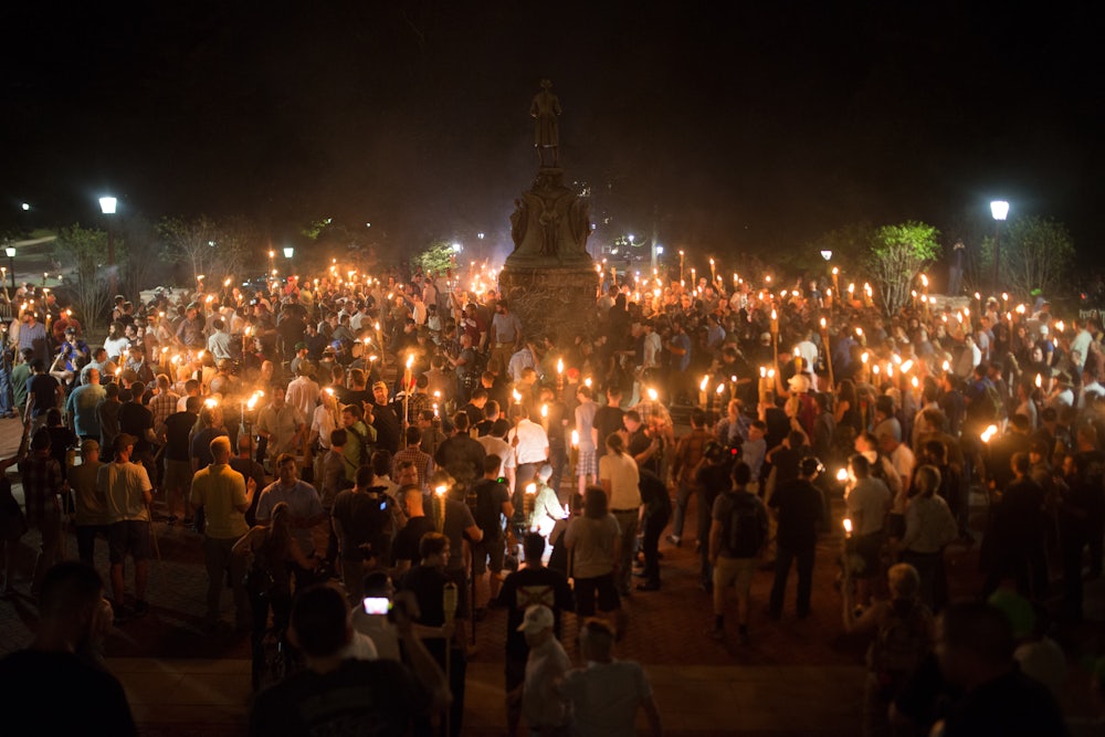 Neo-Nazis, alt-right, and white supremacist terrorists encircle counter protestors at the base of a statue of Thomas Jefferson after marching through the University of Virginia campus with torches in Charlottesville, Virginia.