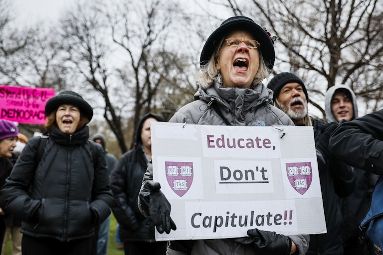 A woman yells while holding a sign that reads "Educate, don't capitulate" featuring the Harvard shield.