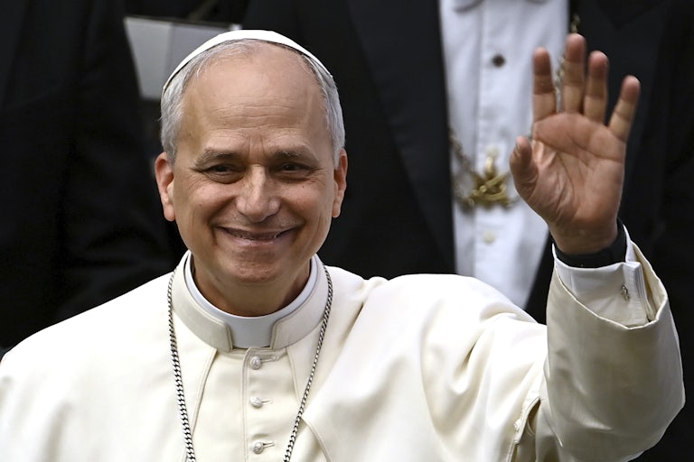 Pope Leo XIV waves while standing in the Vatican
