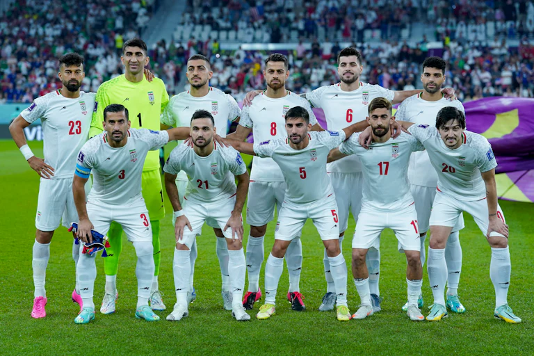 The Iranian men’s soccer team pose for a team photo on the field at the 2022 FIFA World Cup in Doha, Qatar.