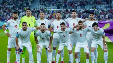 The Iranian men’s soccer team pose for a team photo on the field at the 2022 FIFA World Cup in Doha, Qatar.