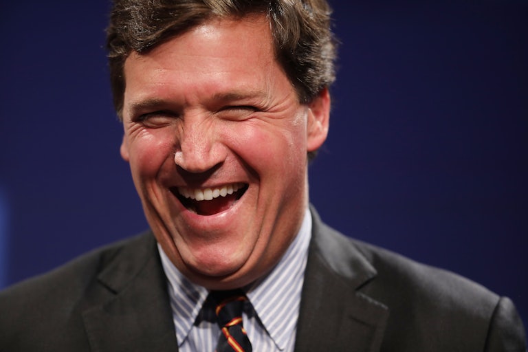 Fox News host Tucker Carlson laughing
