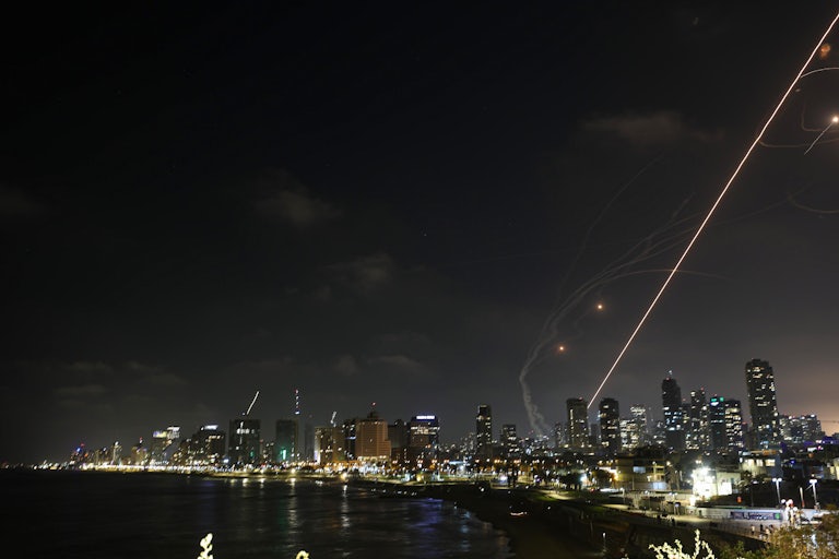 Image of a missile trajectory heading toward Tel Aviv. Smoke rises from the city.