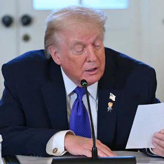 Donald Trump reads a note during a meeting with oil executives