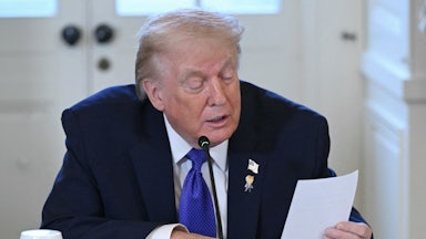 Donald Trump reads a note during a meeting with oil executives