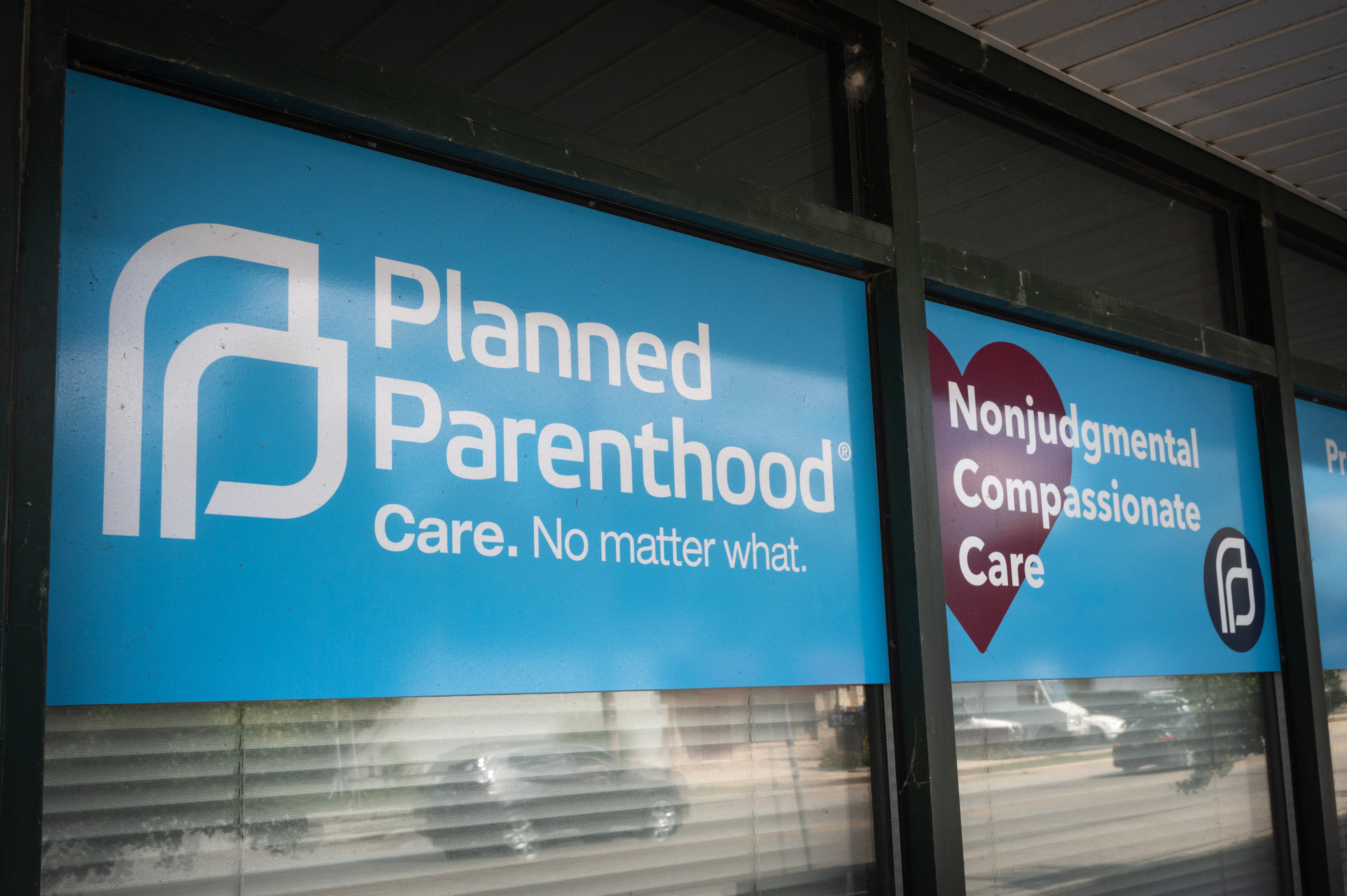 Signs hang in the window of a Planned Parenthood clinic reading "Nonjudgmental Compassionate Care" and "Care. No matter what."