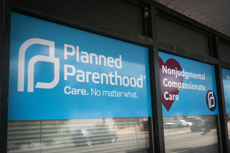 Signs hang in the window of a Planned Parenthood clinic reading "Nonjudgmental Compassionate Care" and "Care. No matter what."