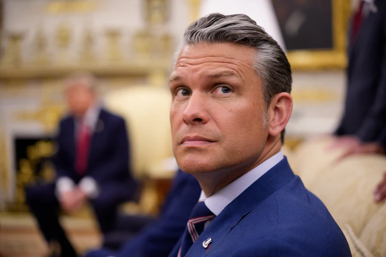 Defense Secretary Pete Hegseth looks up while seated in the Oval Office of the White House