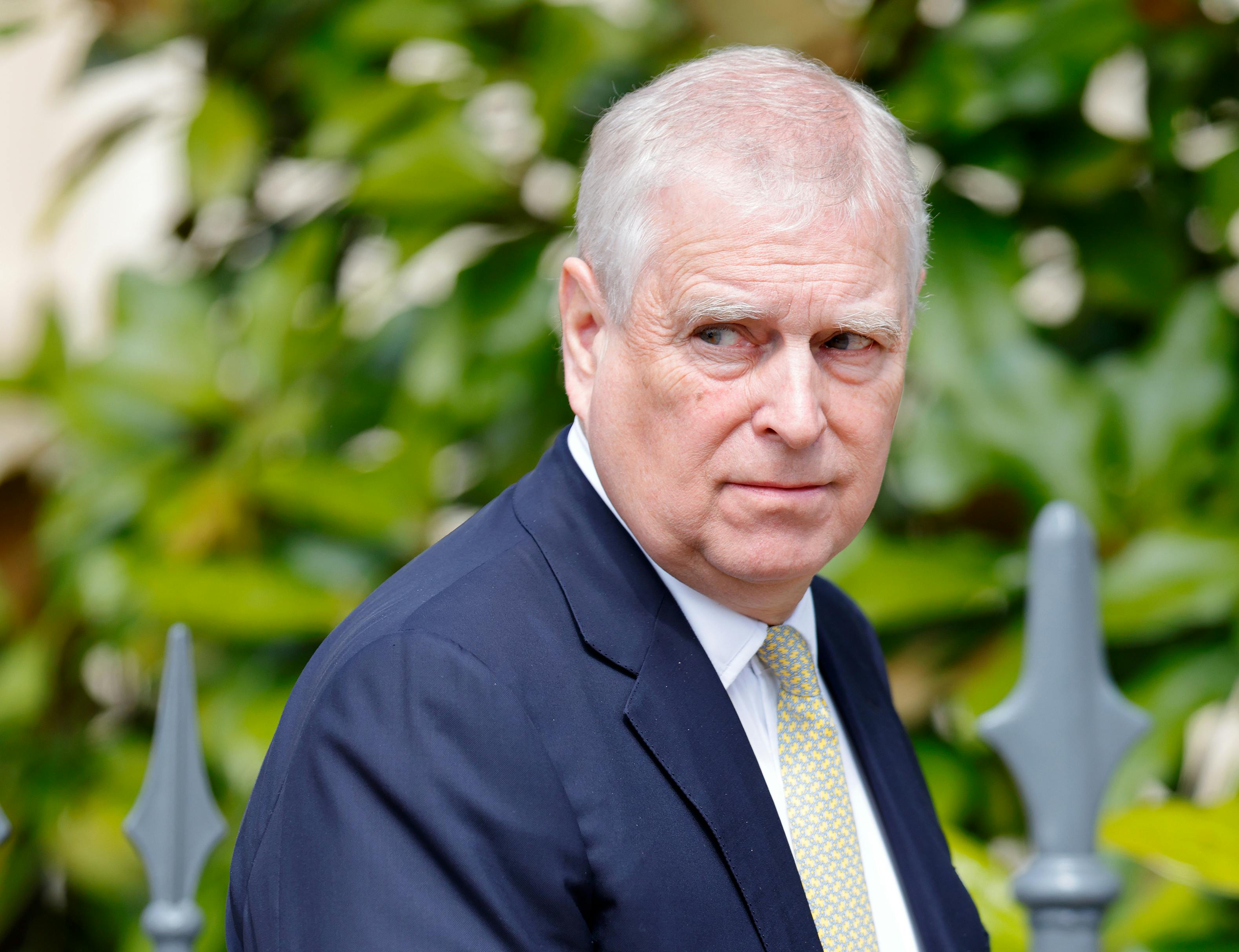 Prince Andrew looks to the side while walking outside