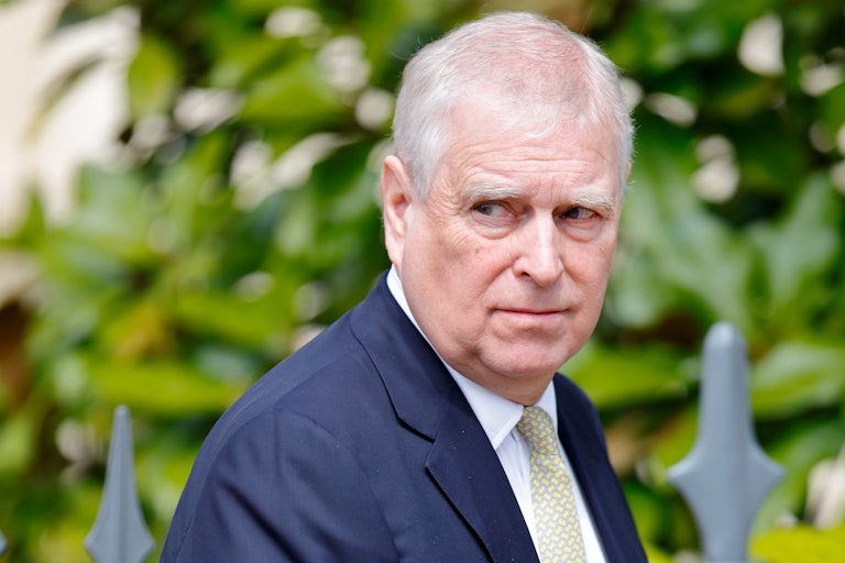 Prince Andrew looks to the side while walking outside