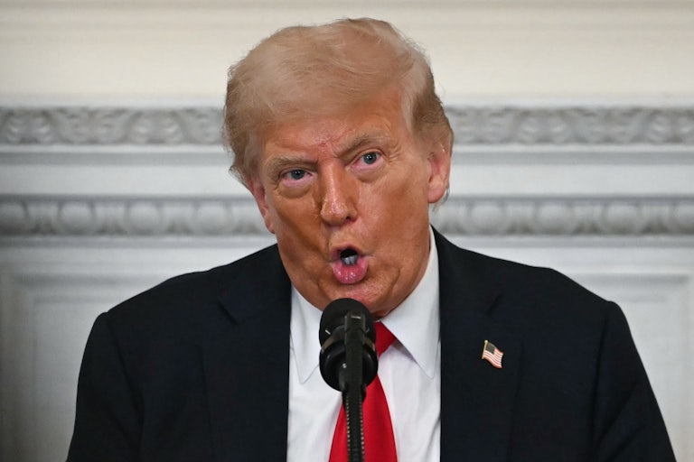 Donald Trump speaks into a microphone during an event at the White House