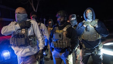 Masked federal immigration agents stand in Minneapolis during an anti-ICE protest