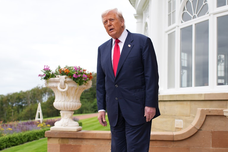 Donald Trump leans forward slightly at the hips and leaves his mouth hanging open. He is on a trip to Scotland.