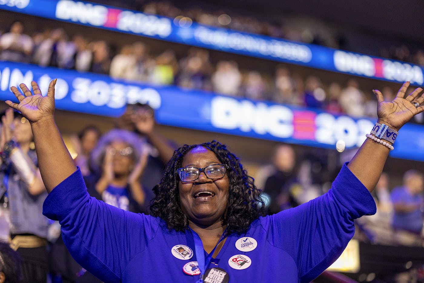 A delegate reacts to the Reverend Jesse Jackson's speech with her hands in the air 