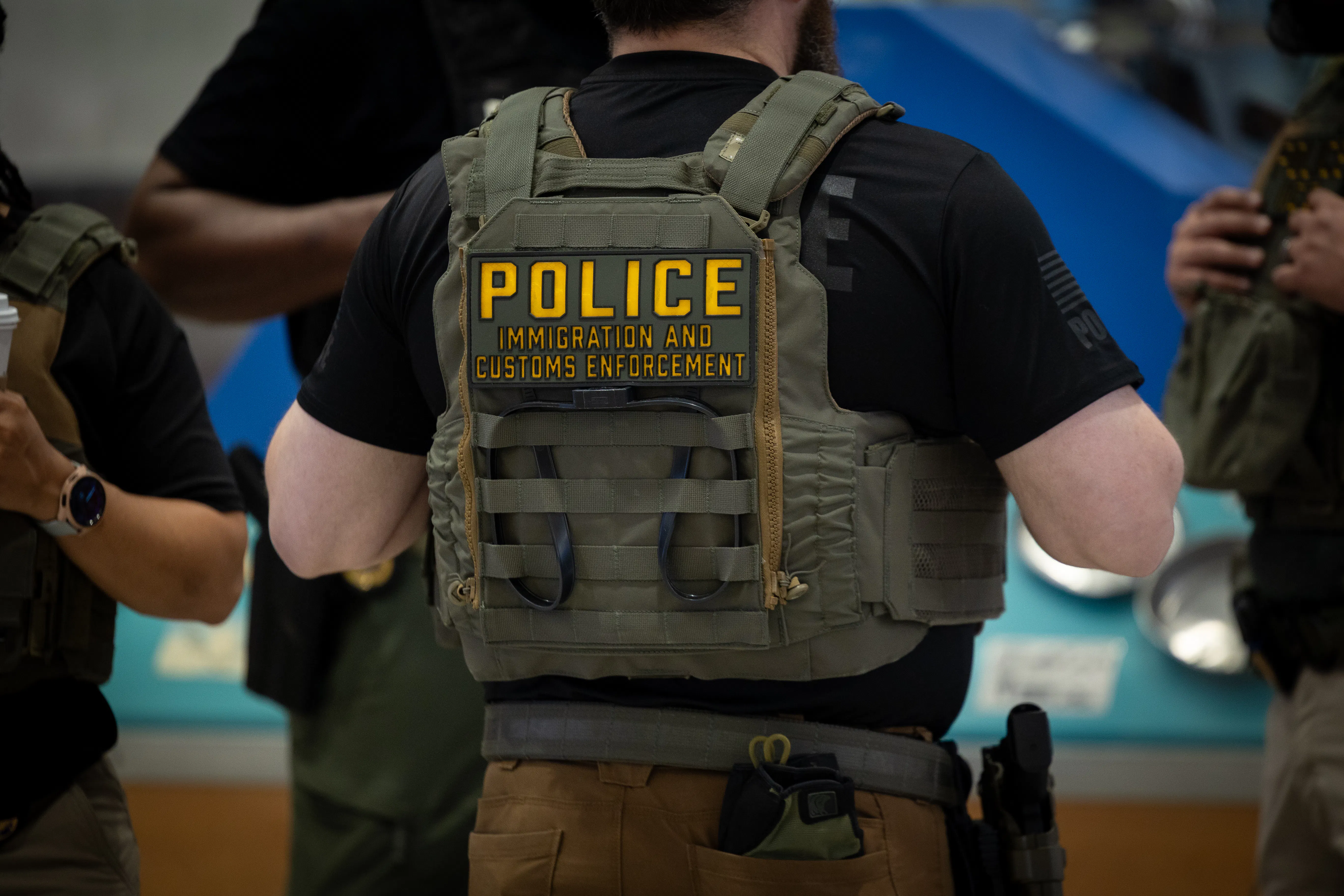 ICE agents stand in an airport