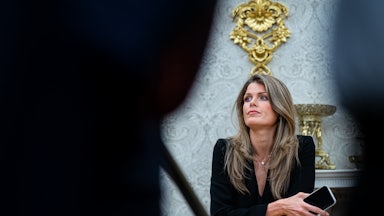 Lindsey Halligan leans on a chair in the Oval Office of the White House.