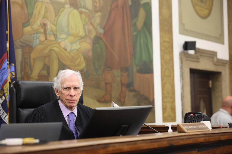 New York State Supreme Court Justice Arthur Engoron smiles at the camera while seated in court