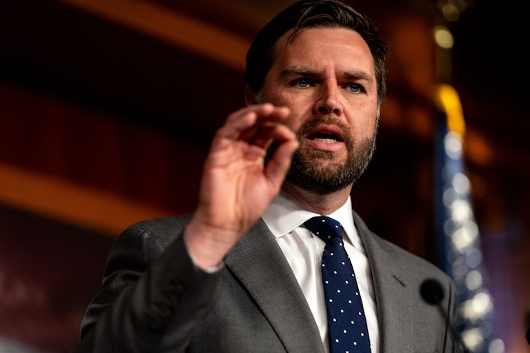 Senator J.D. Vance speaks at a lectern and gestures with his hand