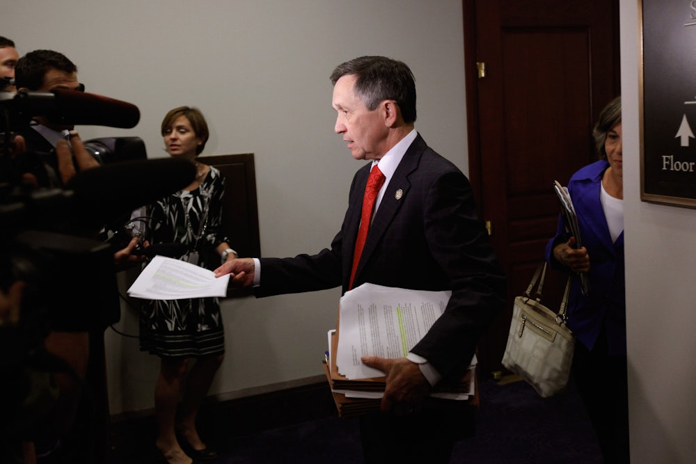 Dennis Kucinich hands out copies of a CBO report to reporters