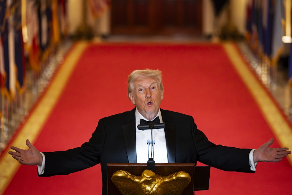 Donald Trump holds his arms out to the side and looks up while speaking at a podium