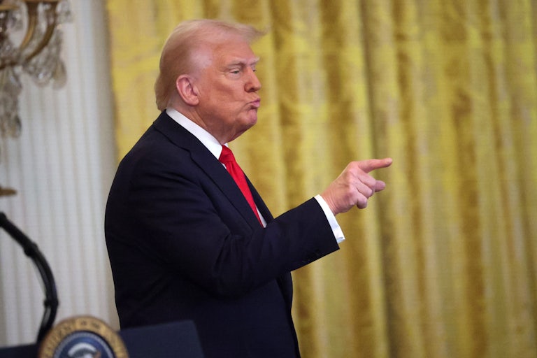 Donald Trump points and purses his lips.