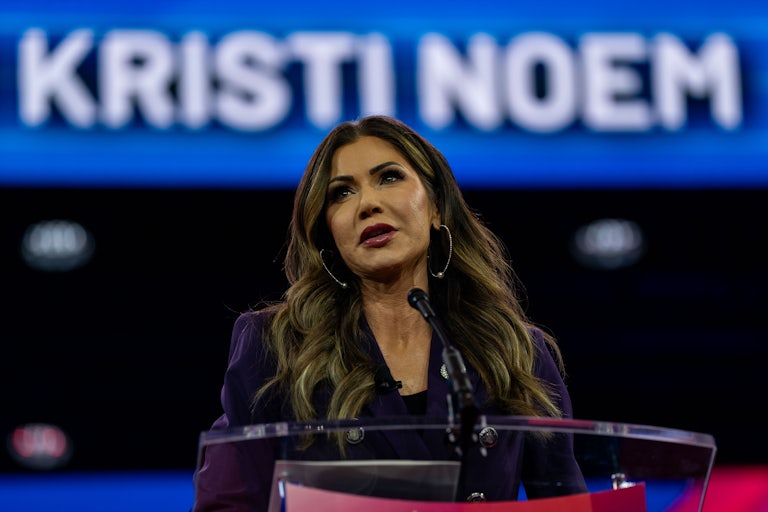 Kristi Noem speaks into a microphone
