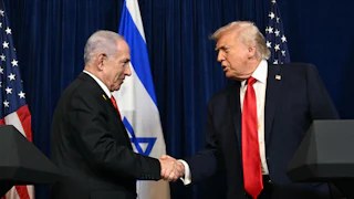 Israeli Prime Minister Benjamin Netanyahu and Donald Trump shake hands while standing at podiums during an event