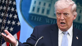 Donald Trump gestures with right hand while standing and speaking