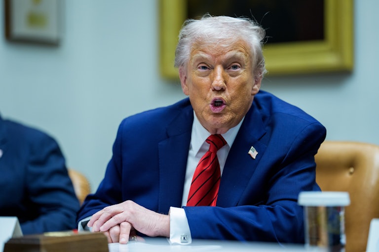 Donald Trump speaks while sitting at a table