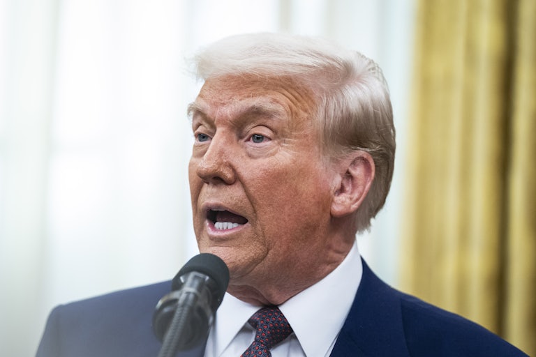 Donald Trump speaks into a microphone during a press conference in the Oval Office