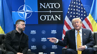 Ukraine’s President Volodymyr Zelenskiy looks on concerned as Donald Trump speaks and points at him.