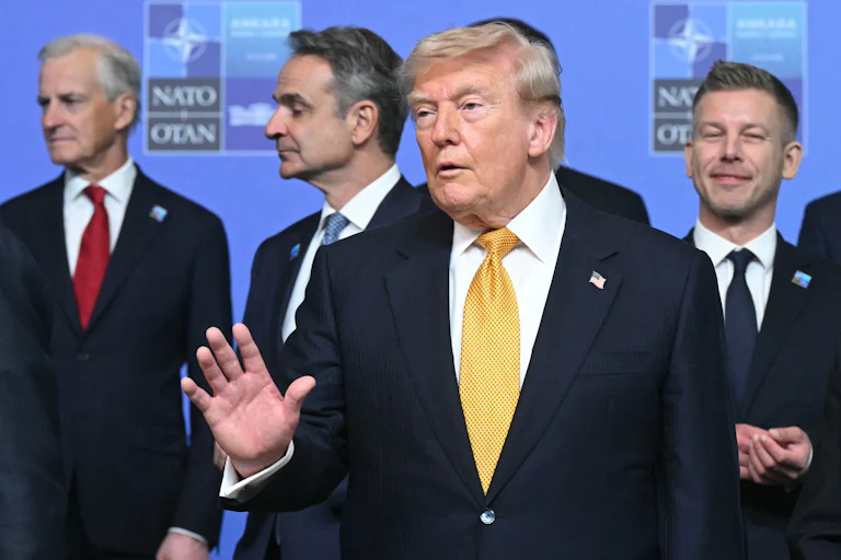 President Donald Trump speaks while standing in front of other NATO leaders.
