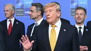 President Donald Trump speaks while standing in front of other NATO leaders.