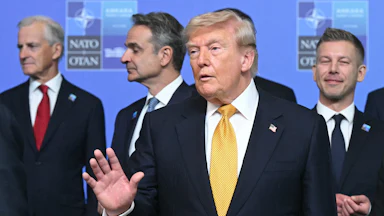 President Donald Trump speaks while standing in front of other NATO leaders.