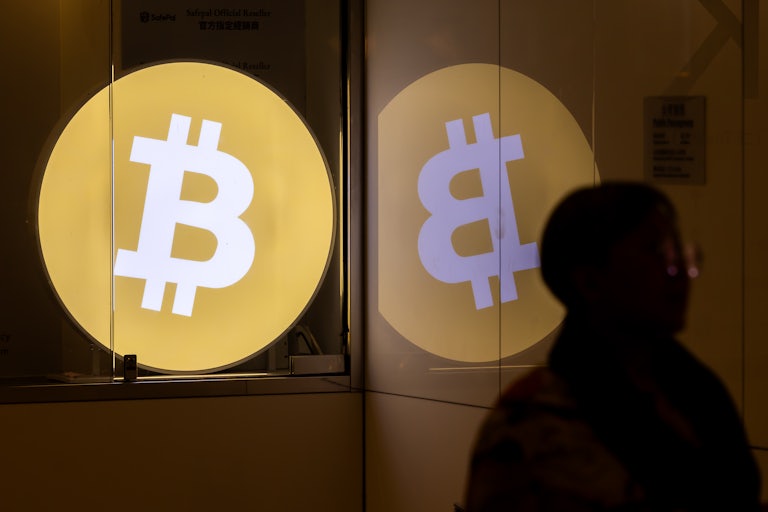 A person walks past the Bitcoin logo