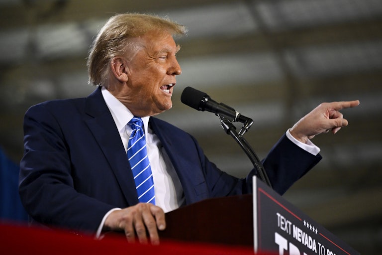 Donald Trump points and yells while speaking at a lectern