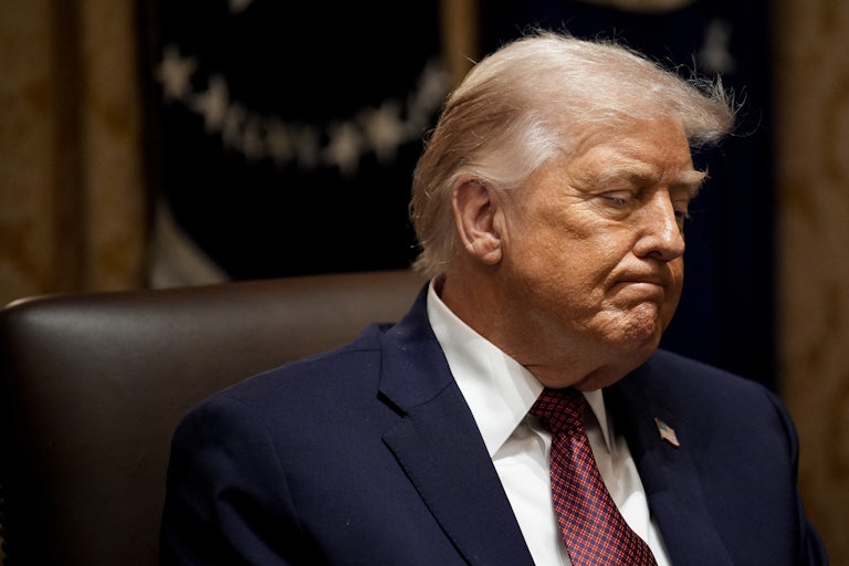 Donald Trump frowns while sitting in the White House Cabinet Room