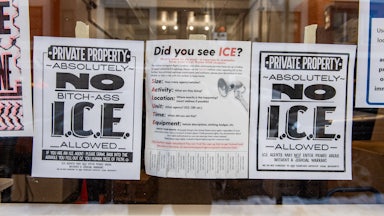 Anti-ICE signs hang in the window of a business in Portland, Maine.