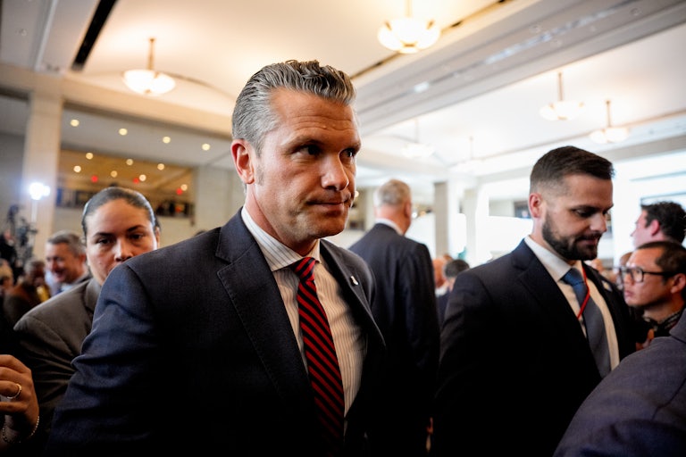 Defense Secretary Pete Hegseth exits a meeting.