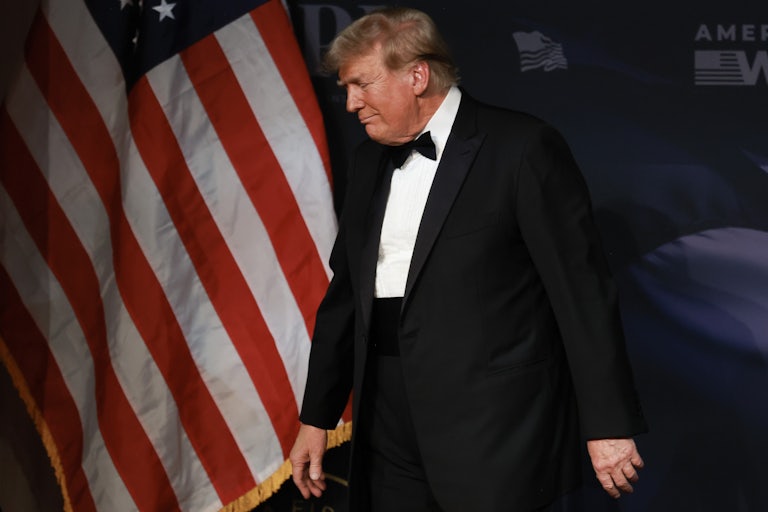 Donald Trump wearing a tuxedo looks down and walks away
