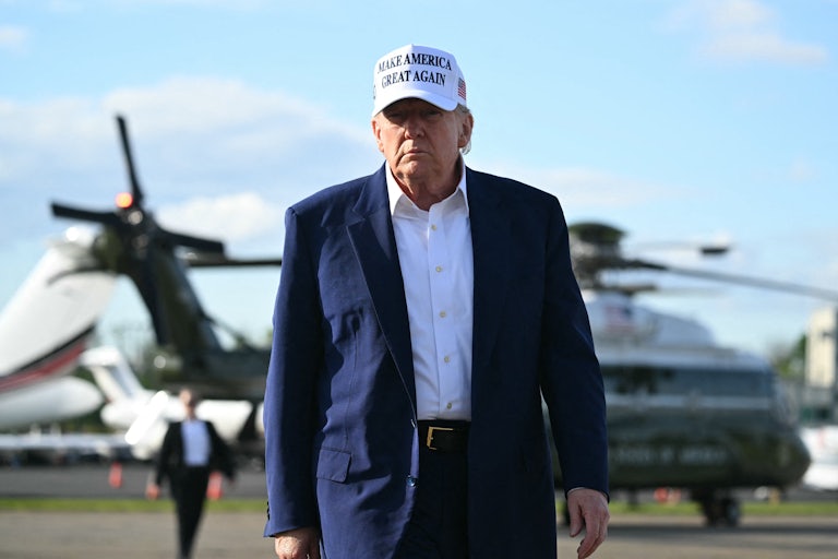 Donald Trump walks on a tarmac