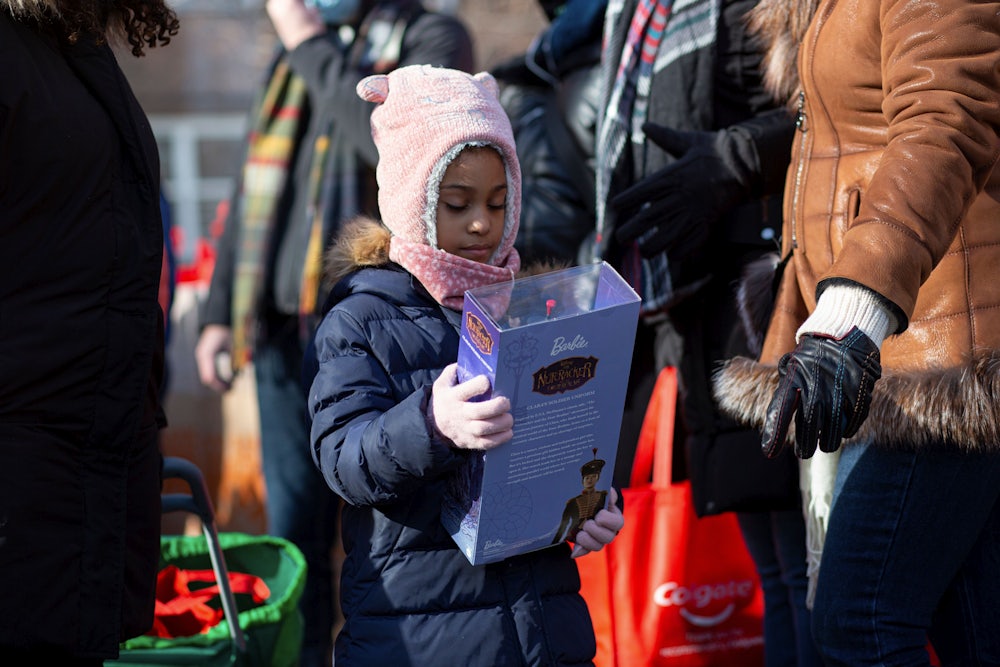 a girl in a hat holds a barbie