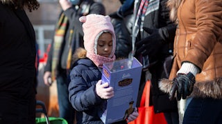 a girl in a hat holds a barbie